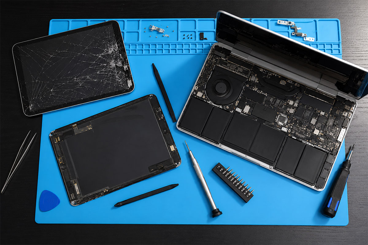 Disassembled iPhone and repair tools laid out on a workbench